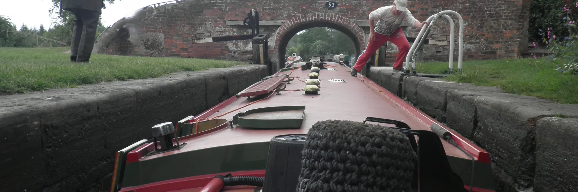 A narrowboat passing under a canal bridge